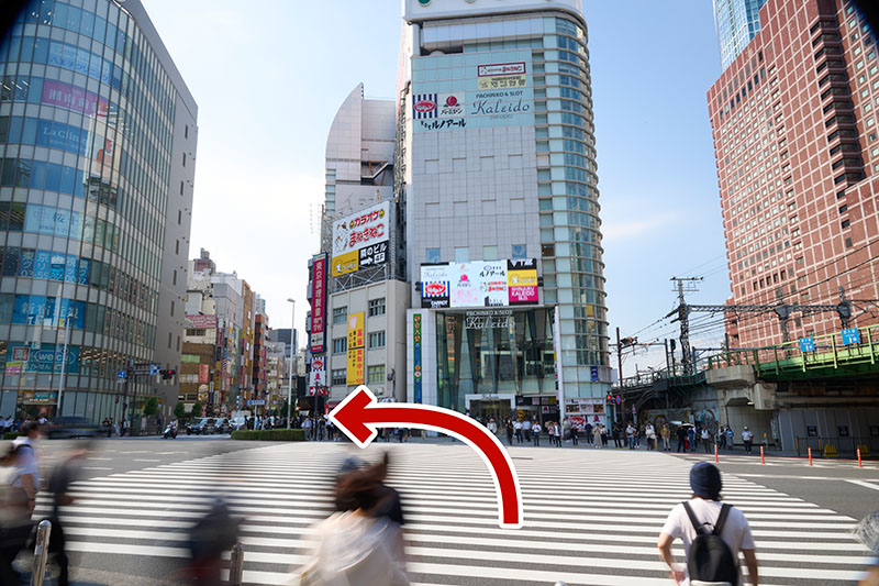 At the intersection located at the Shinjuku Omekaido Overbridge, proceed straight ahead and cross the pedestrian crossing to enter Kotakibashi Street.